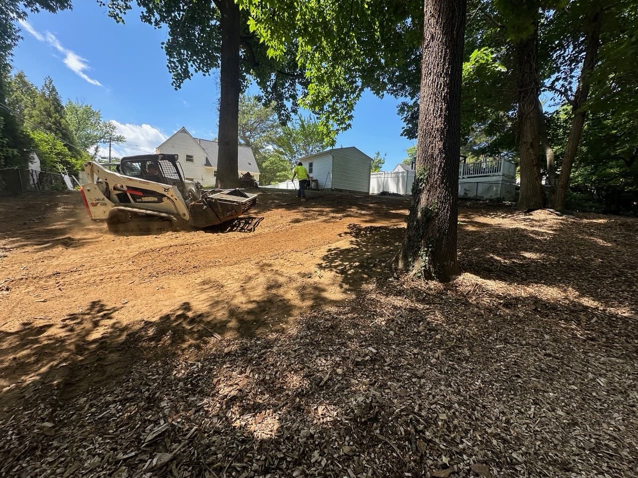 Picture of a construction crew regrading a sloped yard with heavy machinery